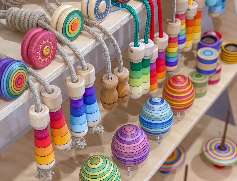 A selection of Mader wooden spinning tops, yo-yos, skipping ropes, kaleidoscopes and eggs in a Steiner classroom setting