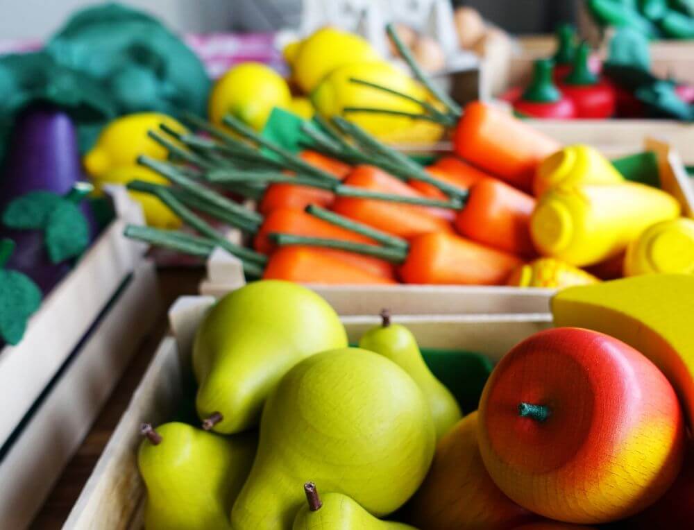 A selection of wooden play food fruit and vegetables from Erzi in a Steiner classroom setting