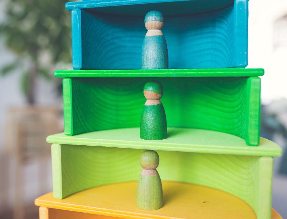 Grimm's rainbow arches stacked on top of each other with wooden semi-circles as bases and colour-matched Grimm's rainbow friends